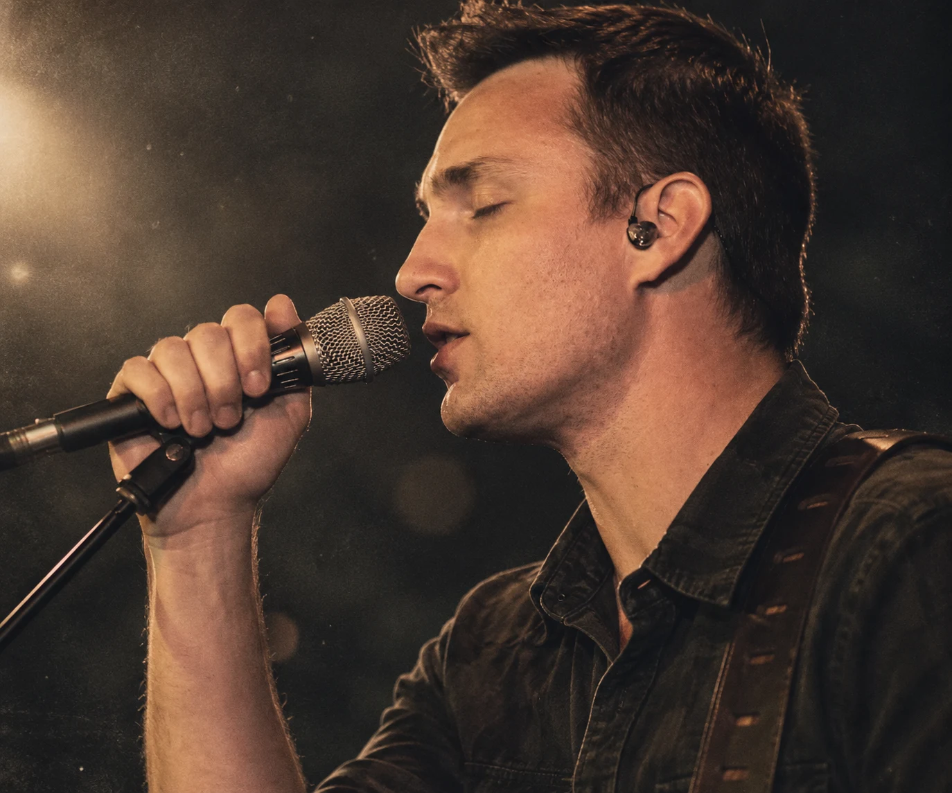 Matt Kindle singing into a microphone on stage